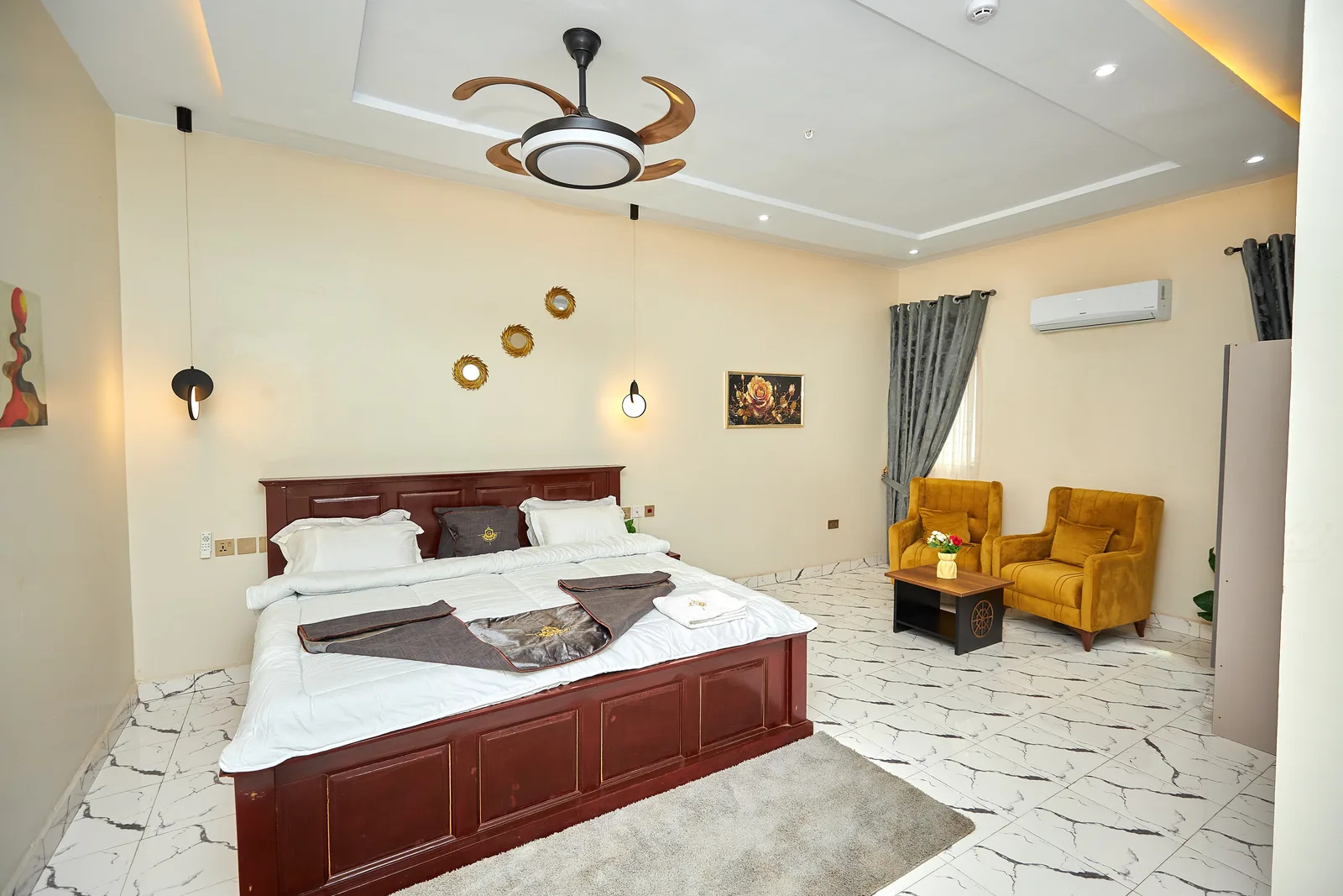 Hotel suite with ochre armchairs and grey curtains