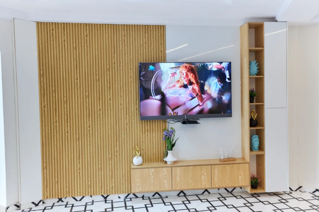 TV wall in slat panels with open shelving