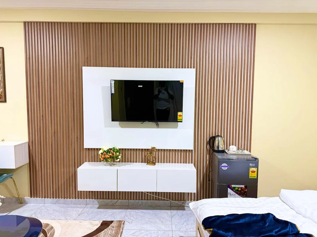 Best Interior Designers in Kumasi, Slat panel TV wall with floating cabinet